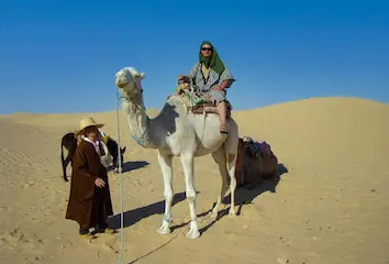 A man enjoying desert safari Dubai with camel ride